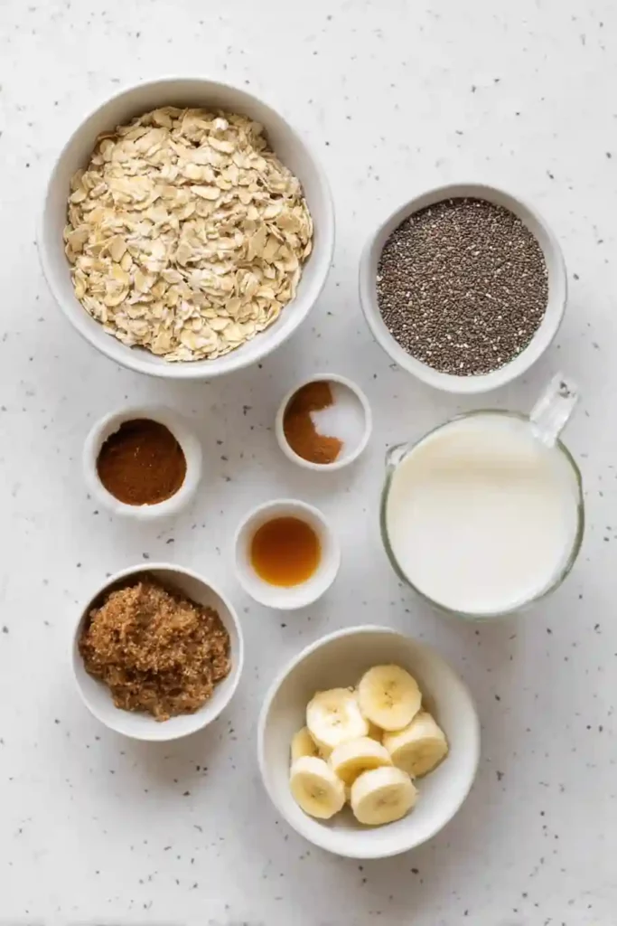 Top view of brown sugar overnight oats ingredients including oats, chia seeds, banana, milk, and brown sugar