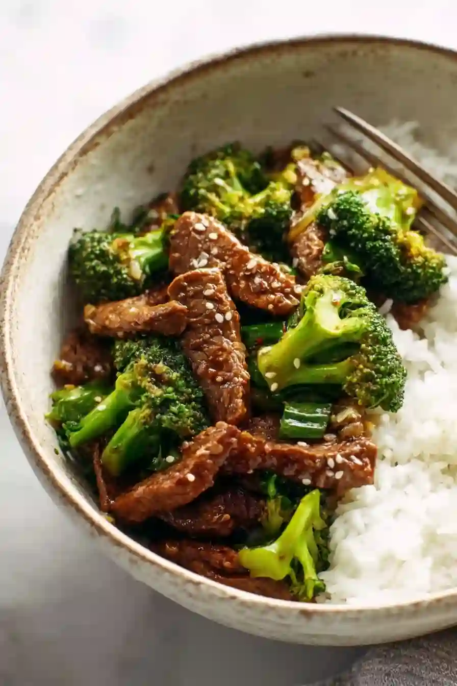 Close-up sesame beef and broccoli with rice in a ceramic bowl