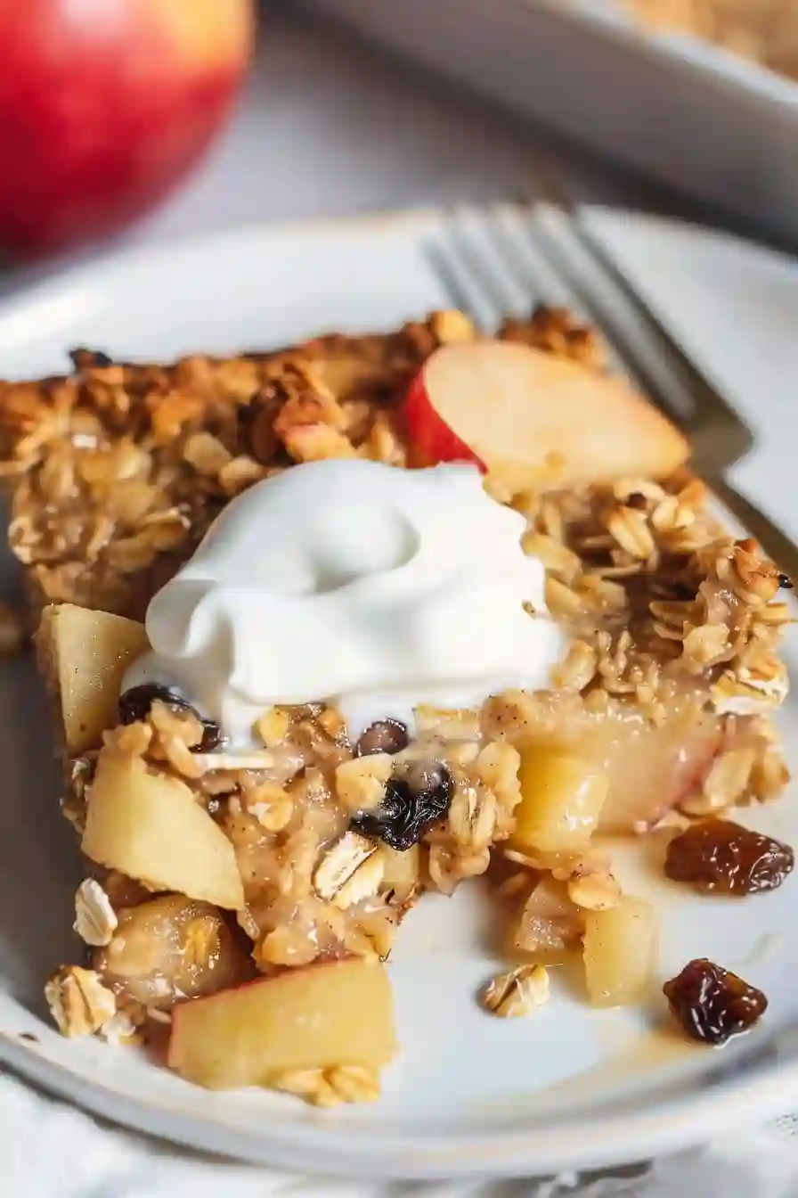 Vertical close-up of baked apple oatmeal with yogurt topping