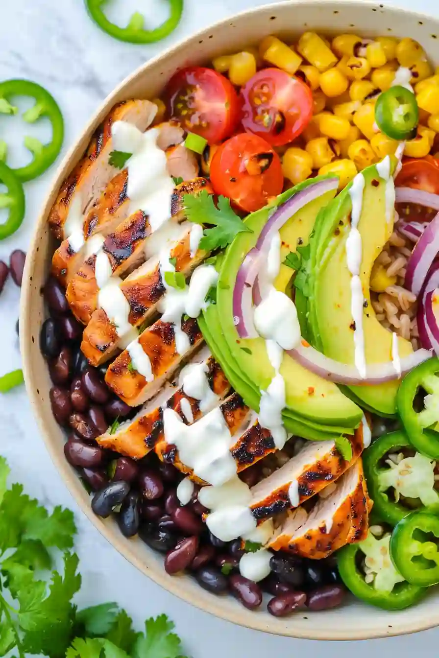 Finished Healthy Chicken Burrito Bowl Healthy chicken burrito bowl topped with avocado beans corn tomatoes and Greek yogurt