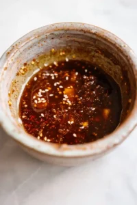 Hawaiian BBQ Chicken (High-Protein) 9 Close-up of Hawaiian BBQ marinade with pineapple juice, soy sauce, and ginger being whisked in a bowl