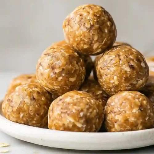 Close-up of homemade peanut butter energy balls stacked on a dark ceramic plate