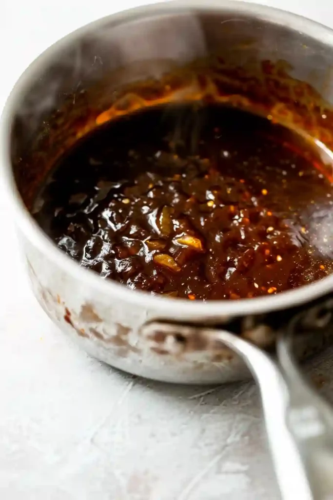 Hawaiian BBQ Chicken (High-Protein) 4 Thick Hawaiian BBQ sauce simmering in a saucepan with glossy caramelized texture