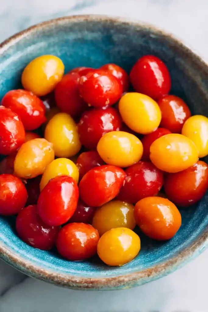 Red, White & Blue Summer Salad with Berries and Mozzarella 3 Fresh cherry tomatoes soaking in white balsamic vinaigrette inside a rustic bowl.