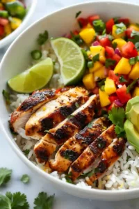 Mango Salsa Chicken Bowl with Cilantro-Lime Rice 9 Prepared mango salsa chicken bowl with warm rice, sliced chicken, fresh salsa, and lime wedge ready to serve.