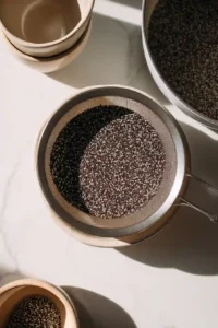 Quinoa Black Bean Salad with Lime Cumin Dressing 5 Quinoa being rinsed in a fine mesh sieve over a sink before cooking in a saucepan