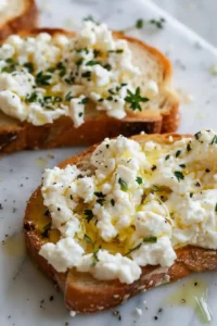 Cottage Cheese Toast with Tomatoes 4 Golden toasted bread topped with olive oil and a thick layer of creamy cottage cheese.