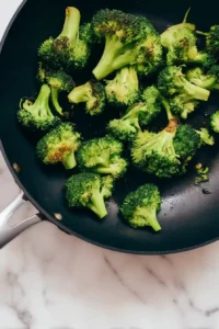 Meal Prep Honey Garlic Chicken Bowls 8 Fresh broccoli florets stir-fried in a skillet with lightly charred edges.