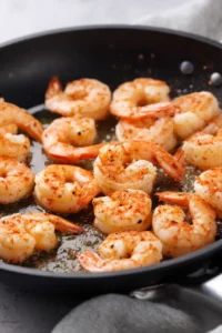 Garlic Butter Shrimp with Broccoli 4 Large shrimp seasoned with paprika cooking in olive oil until pink and opaque.