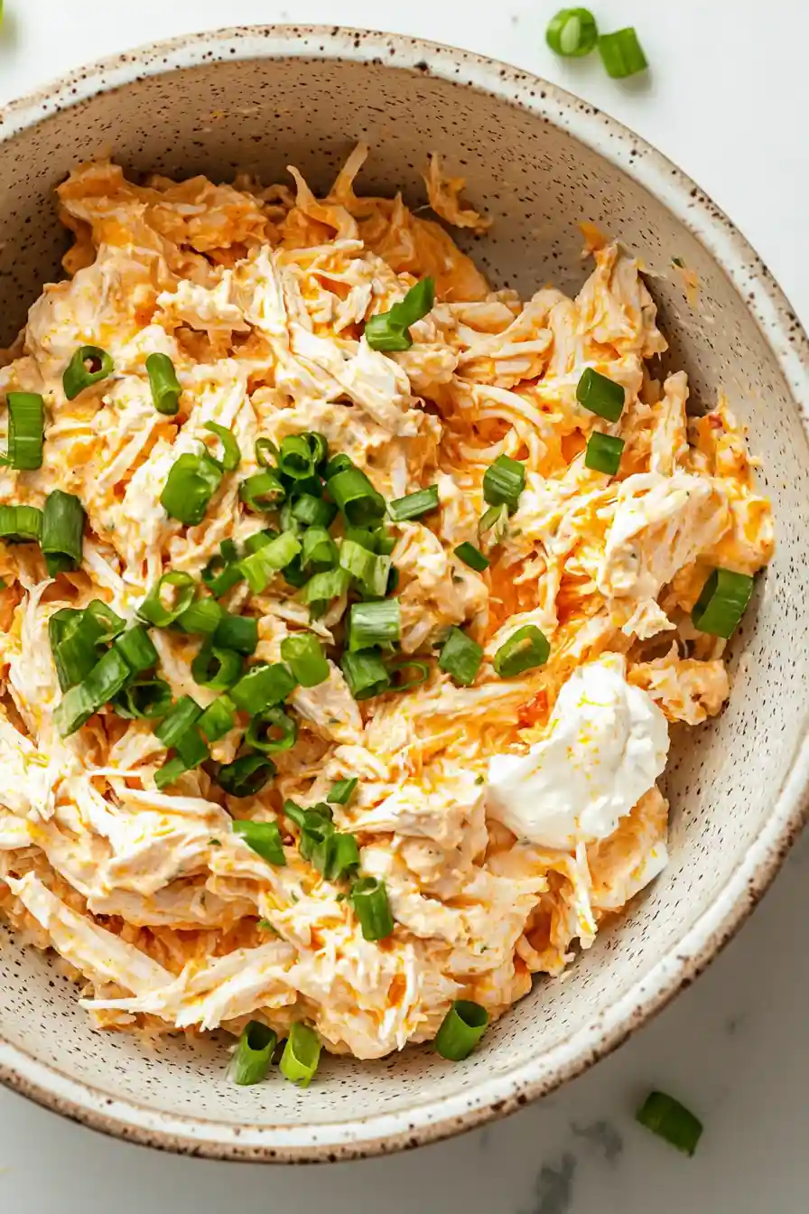 Creamy buffalo chicken filling made with shredded chicken, cream cheese, Greek yogurt, buffalo sauce, cheddar cheese, and green onions.