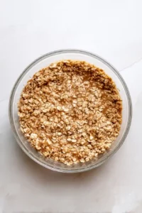 Rolled oats mixed with almond milk, applesauce, maple syrup, cinnamon, and flaxseed