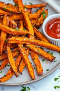 Crispy air fryer sweet potato fries served immediately with fine sea salt and ketchup.